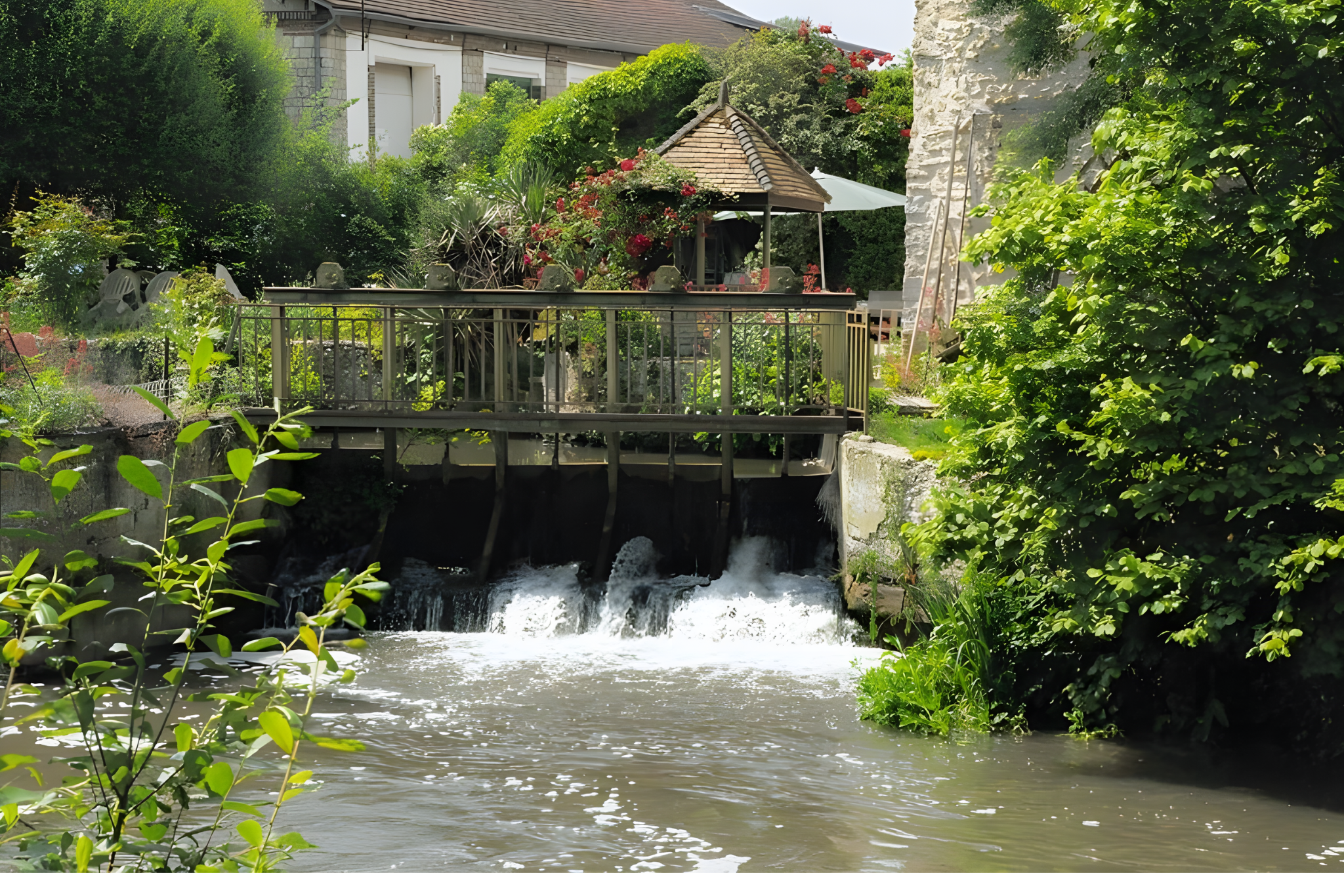 Moulin avec chute d’eau entouré de végétation