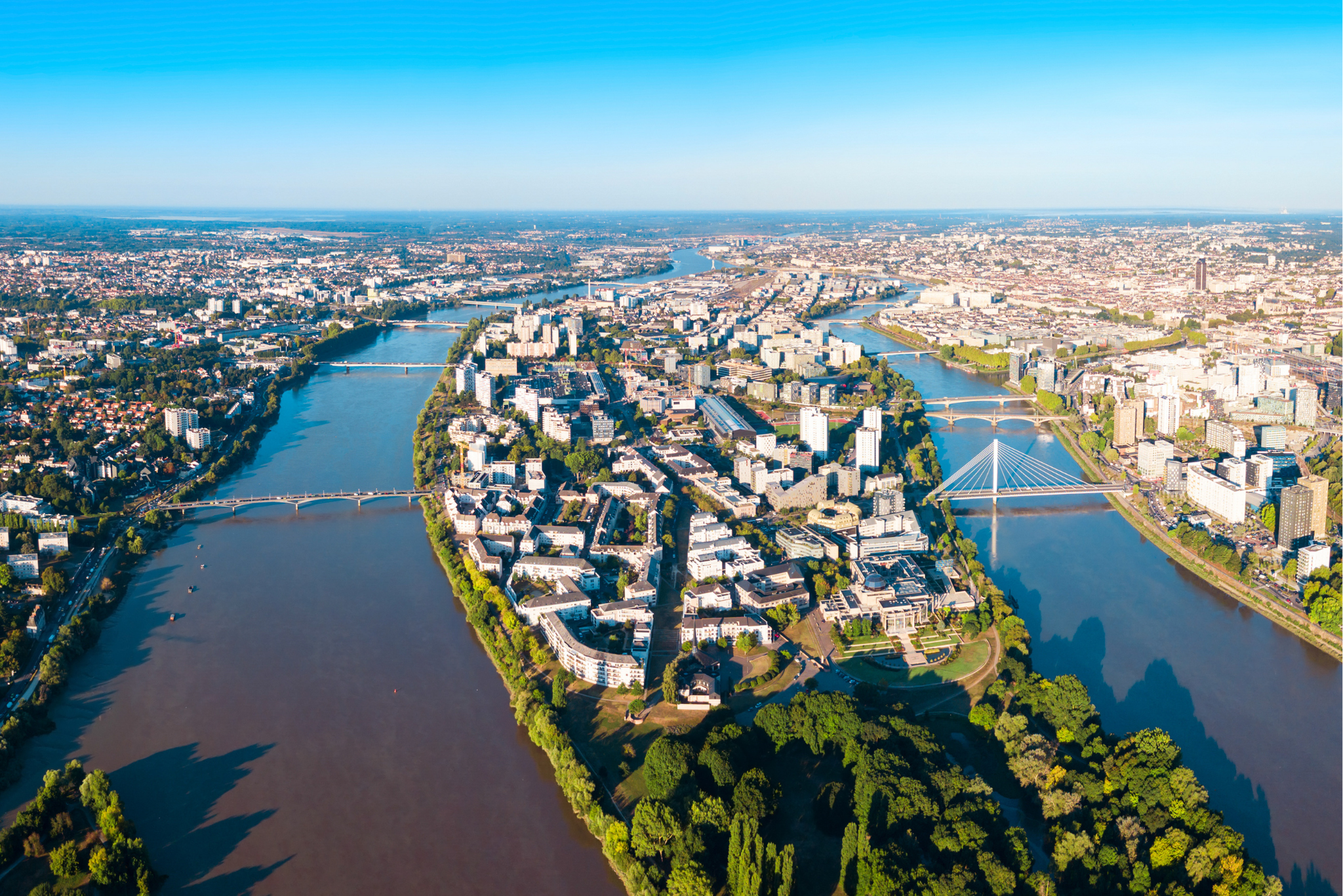 Vue aérienne d’une ville traversée par une rivière avec ponts et quartiers résidentiels